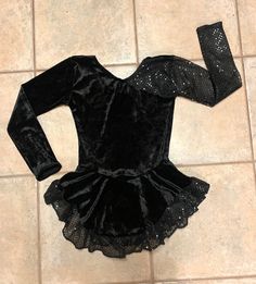 "This custom made, long-sleeved dress is made of a black VELVET with the sleeves and ruffled hem made of a black confetti dot, sequined material. Has a high neckline with lower back. The skirt is gathered at the waist and attached underneath is the matching brief. Measurements: SIZE BUST WAIST HIPS GIRTH 4-6 20-21\" 19-20\" 22-23\" 37-38\" 6x-7 22-23\" 20-21\" 23-25\" 41-42\" 8-10 24-25\" 21-22\" 25-27\" 44-45\" 12-14 26\" 22-23\" 27-29\" 46-48\"" Fitted Long Sleeve Velvet Dress, Winter Costume Dress With Long Sleeves, Winter Costume Long Sleeve Dress, Black Stretch Dress For Dance, Long Sleeve Winter Costume Dress, Fitted Long Sleeve Sequin Dress For Fall, Winter Long Sleeve Costume Dress, Fitted Long Sleeve Dress With Sequins For Fall, Black Fitted Velvet Dress