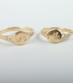 two personalized gold rings with diamonds on each side and the initials are in different sizes