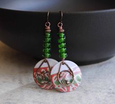 A different twist to your usual holiday earrings featuring green and reddish coral enamel charms. The abstract pattern on the enamels reminds me of a tree branch. I have paired them with spiraling green lampwork beads and copper beads. I have accented them with teardrop shaped copper components. These unique earrings measure 2 1/2 inches in total length and hang on niobium earring hooks. All pieces come boxed ready for gift giving or keeping for yourself. Return to shop: bstrung.etsy.com More li Bohemian Green Jewelry For Holiday, Green Spiral Earrings As Gift, Christmas Party Earrings, Blue And White Earrings, Lampwork Bead Earrings, Bohemian Christmas, Black And White Earrings, Boho Chic Earrings, Lampwork Earring