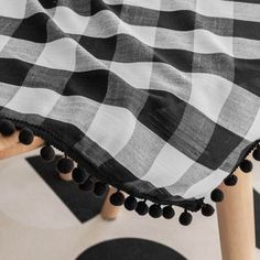 a black and white checkered blanket with pom - poms on the back