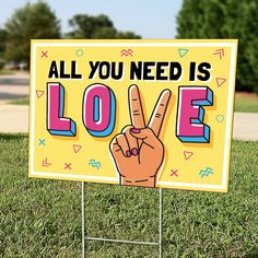 a sign that says, all you need is love with a peace hand on it