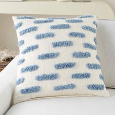 a blue and white pillow sitting on top of a couch