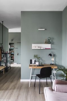 a living room filled with furniture next to a wooden table and bookshelf on top of a hard wood floor