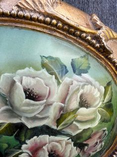 a painting of white flowers in a gold frame