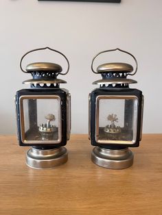 two small metal objects sitting on top of a wooden table