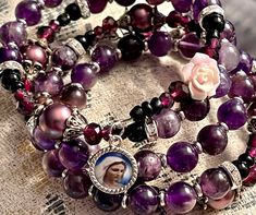 "Welcome to my Shop \"CREATING STILL MOMENTS.\"   To see all my listings and offerings, please visit my shop at  https://www.etsy.com/shop/CreatingStillMoments?ref=sh-carousel- Handmade Rosary Bracelet Semi-precious purple agate beads Memory Wire Mary Medal silver crucifix with St Benedict medal and lavender rose bead for added pop of color Catholic mom gift  Beads of brilliant color!  These rosaries are beautiful and would make a wonderful RCIA Gift or Confirmation gift! The colors are vibrant Purple Round Beaded Jewelry For Mother's Day, Adjustable Purple Rosary Bracelet, Adjustable Purple Spiritual Rosary Bracelet, Handmade Spiritual Purple Rosary Bracelet, St Benedict Medal, Handmade Rosary, Benedict Medal, Beaded Memory Wire, Catholic Jewelry