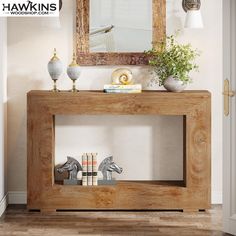 a wooden console table with an animal figurine on top and a mirror above it