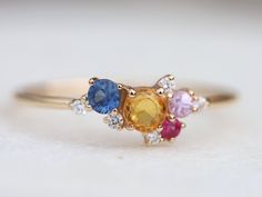 three different colored stones on a gold ring