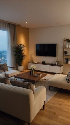 a living room filled with furniture and a flat screen tv mounted on the wall above it