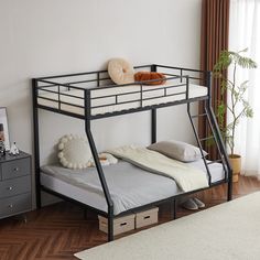 a black metal bunk bed sitting on top of a hard wood floor next to a window