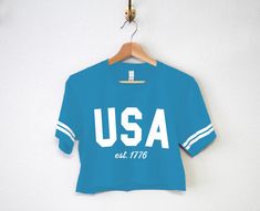 LOW SUPPLY FLASH SALE!! Only 5 of each size available, then they are gone! Pick Between "USA est. 1777", "America", or "Cheers Merica" USA est. 1776 Patriotic 4th of July Crop Top Shirts for women The perfect shirts for any Independence day party! Shirt Colors Available: Aqua blue with White Stripes Women's Sizes Available: S, M, L These run true to size. We recommend sticking with your normal shirt size, unless you are in between sizes or prefer a looser fit then order a size up. Affordable Blue Tops For Independence Day, America Shirts, 4th Of July Shirts, Usa Patriotic, Cropped Tops, Crop Top Shirts, Cropped Tube Top, Shirts For Women, Perfect Shirt