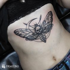 a woman's stomach with a butterfly tattoo on it