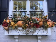 a window sill filled with pumpkins and gourds