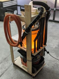 a machine that is sitting on top of a wooden stand with two hoses attached to it