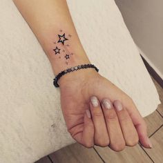 a woman's hand with a star tattoo on it