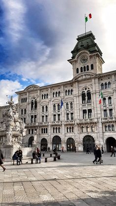 people are walking around in front of a large building