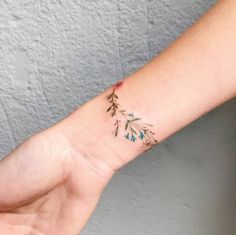 a woman's arm with a small flower tattoo on the left side of her wrist