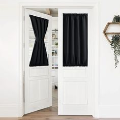 the black curtains are hanging on the white door