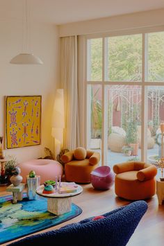 a living room filled with furniture and large windows