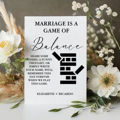 a card with the words marriage is a game of balance on it next to flowers