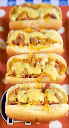 four hot dogs covered in cheese and bacon