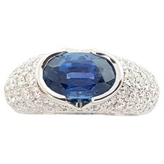 an oval blue sapphire and diamond ring in white gold with diamonds around the band, set on