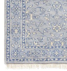 a blue and white rug with fringes on the bottom, in front of a white background