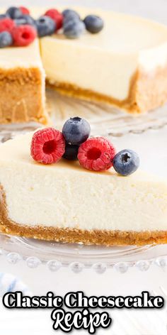 a cheesecake with berries and blueberries is on a glass plate next to the rest of the pie