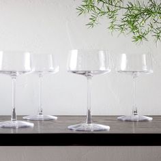 four empty wine glasses lined up on a table