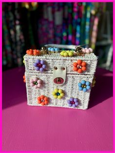 Beautifully embellished wicker box daisy bag with wooden top handle and turn-lock closure. This bag is perfect for any occasion from tropical vacations to Saturday brunching with friends. This bag ships with a 53” gold shoulder chain as well, turning it into a fun crossbody bag. Details: White wicker box Fits iPhone 15 Pro vertically and horizontally along with wallet, keys, and your favorite lipgloss Measures 6.29” X 3.34” X 7.5” Summer Top Handle Straw Bag As Gift, Spring White Straw Bag As Gift, Spring White Straw Bag For Gift, Daisy Bags, Wicker Box, Tropical Vacations, Bag Details, White Wicker, Colorful Candy