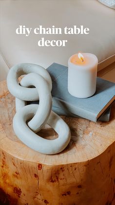 a candle sits on top of a wooden table next to a book and some books