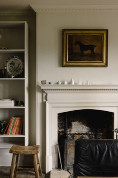 a living room filled with furniture and a fire place in front of a painting on the wall