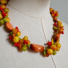 Super cute "Tutti Frutti" Fruit Salad Necklace dating from the 1950's  Stamped West Germany. * Clusters of  Plastic "Fruit" all the full length of the necklace * Seperated by Wooden Beads  * "Box" Insert Clasp Closure disguised in a fruit cluster  Full Length: 20" inches  Fruit Clusters are Approx 1" inch thick  Condition : Excellent * There is some loss of the metallic paint to the tiny interlinking beads that join the fruit clusters and the wooden beads (but they are hardly visible and it's no Handmade Vintage Yellow Beaded Necklaces, Retro Orange Jewelry For Party, Retro Handmade Necklace For Gift, Retro Orange Necklace Gift, Handmade Retro Necklaces For Gifts, Handmade Mid-century Jewelry Gift, Handmade Retro Necklace For Gift, Retro Handmade Adjustable Beaded Necklaces, Handmade Retro Adjustable Beaded Necklaces