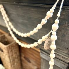 a white beaded necklace hanging from a string on top of a wooden fireplace mantel