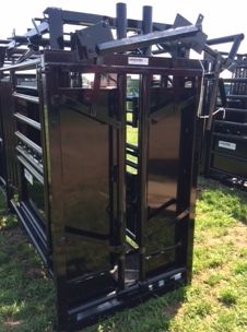 a large group of black metal containers sitting on top of a grass covered field next to each other