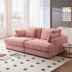 a pink couch sitting on top of a white rug