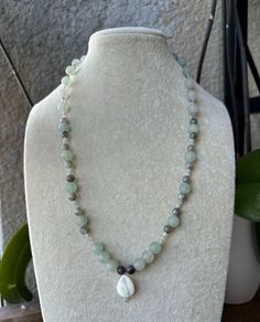 This is a gorgeous gemstone necklace that I created out of natural Labradorite, Adventurine, and Mother of Pearl. It is brought together with a Sterling Silver lobster clasp and is on the longer side, measuring 16 3/4 inches in length. It has a teardrop Mother of Pearl pendant as the center with the body of the necklace in different shades of blue and grey. It is handmade by myself and will make the perfect addition to one's jewelry collection.  Mother Of Pearl: Known to attract prosperity Labradorite: Known to be one of the most powerful protectors Adventurine: Known as "The Stone of Opportunity" Other Materials: Thank you for shopping GemsOfGaea! Elegant Labradorite Beaded Necklace For Gift, Adjustable Beaded Labradorite Necklaces, Adjustable Labradorite Gemstone Bead Necklace, Elegant Labradorite Beaded Necklaces, Spiritual Green Labradorite Necklace, Earthy Jewelry, Handmade Beads, Pearl Pendant, Gemstone Necklace