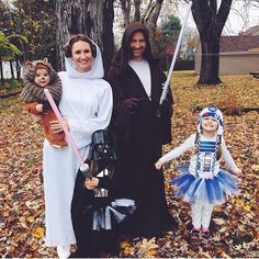 three people dressed in costumes posing for the camera with two children and one adult holding a child's hand