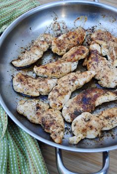 some chicken is cooking in a pan on the table