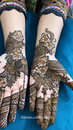 two hands with henna tattoos on them