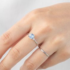 One of a kind, the ring in the photo is what you will receive 0.91ct Montana Sapphire, 5.5x5.5x3.37mm, heat treated, a white feather inclusion near the edge 0.04ctw G color SI clarity white accent diamonds Band width x height: approx. 1.4mm x 1.6mm Hight profile, four-prong flower setting Made of 100% recycled solid 14k white gold and ethically sourced gemstones Ring Size This ring is currently size 7, and can be resized 3~8.5 in 10 days. For other ring size, it is going to be a semi-custom orde Light Blue Diamond Ring With Brilliant Cut, 14k White Gold Round Cut Jewelry For Proposal, Rose Gold Topaz Ring With Diamond Prong Setting, Brilliant Cut Diamond Proposal Ring With Open Design, Rose Gold Brilliant Cut Topaz Ring, Dainty White Gold Wedding Ring With Round Cut, Classic Light Blue Diamond Ring, Classic Light Blue Brilliant Cut Jewelry, Fine Jewelry Light Blue Diamond Ring With Center Stone