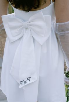 On par for the 2024 and 2025 brides! Bows are the IT accessory so what better way to add it it any and every bridal outfit you have! This double bow will surely be the center of attention. Easily pin it to a dress or bikini for your bachelorette. Personalization is beautifully embroidered for that lasting touch. Elegant Wedding Dress With Detachable Bow, Satin Wedding Dress With Detachable Bow, Fitted Satin Bow For Wedding, Elegant Ribbon Bow For Wedding, White Ribbon Bow For Wedding, Elegant Wedding Bow With Ribbon, Personalized Bow, Center Of Attention, Bridal Outfit