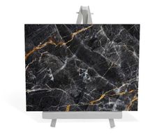 black marble with gold veining on an easel, isolated against a white background