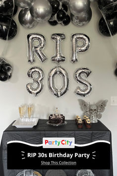 a birthday party with balloons, plates and cake on a table in front of a sign that says rip 80's