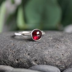 Garnet symbolizes love and is the gemstone to give for the 2nd anniversary. It is also the birthstone for January. This simple sterling silver stacking ring is a great gift, or an addition to a collection of stacking rings. Here are the details: This ring is made with a 4mm or 5-6mm bezel set garnet cabochon set on a sturdy sterling silver band handmade in your size. It can be worn with other stackable rings, or by itself.Please select your ring size. Sizes are US based. Classic Sterling Silver Birthstone Ring, Classic Sterling Silver Birthstone Ring With Round Stone, Classic Everyday Stackable Gemstone Rings, Everyday Solitaire Stackable Rings, Classic Stackable Birthstone Ring For Promise, Classic Stackable Birthstone Promise Ring, Stackable Sterling Silver Birthstone Ring Fine Jewelry, Fine Jewelry Stackable Birthstone Rings With Round Cut, Minimalist Sterling Silver Stackable Rings With Round Cut