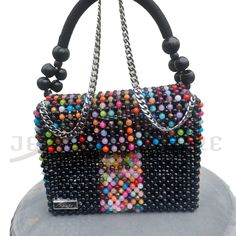 This one-of-a-kind, finely assembled, marble pattern bead by bead black and a multicolor bag is designed in a fold-over silhouette with two different straps (chain and wooden beaded nylon rope strap) and a magnetic snap that opens to reveal room for all your essentials. * Black and multicolor round beads * Marble pattern beads * Gold-tone hardware * Magnetic snap closure * Flap style * Unlined * Detachable straps * Shoulder length chain strap * Wooden beaded nylon rope strap * 8.5"W X 6"H X 3"D Luxury Multicolor Bags With Chain Strap, Luxury Multicolor Bag With Chain Strap, Trendy Multicolor Shoulder Bag For Evening, Multicolor Beaded Rectangular Shoulder Bag, Multicolor Rectangular Shoulder Bag With Colorful Beads, Black Beaded Square Shoulder Bag, Evening Multicolor Shoulder Bag With Adjustable Strap, Trendy Multicolor Beaded Shoulder Bag, Multicolor Square Beaded Bag