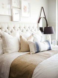 a bed with white linens and pillows in a bedroom