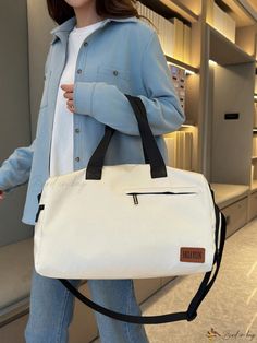 a woman carrying a white bag with black handles