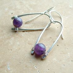 Unique amethyst statement earrings. My signature inverted hoops in silver with a luscious purple amethyst nestled within, Made from sterling silver that's been hand formed and forged, then buffed to a nice sheen. The silver inverted hoops are about 1 inch by themselves (not including the earwires). Please see measurement photo to get an accurate idea of the size of these earrings. You can enter my main shop here: http://www.etsy.com/shop/ArtistiKat Photos and content © K Davis Studios PLEASE rea Modern Purple Jewelry As A Gift, Modern Purple Jewelry For Gifts, Modern Purple Gemstone Earrings, Modern Purple Gemstone Jewelry, Modern Purple Amethyst Jewelry, Nickel-free Purple Dangle Hoop Earrings, Silver Amethyst Wire Wrapped Earrings, Purple Nickel-free Dangle Hoop Earrings, Modern Amethyst Gemstone Earrings