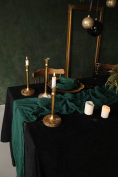 the table is set with candles and green cloth